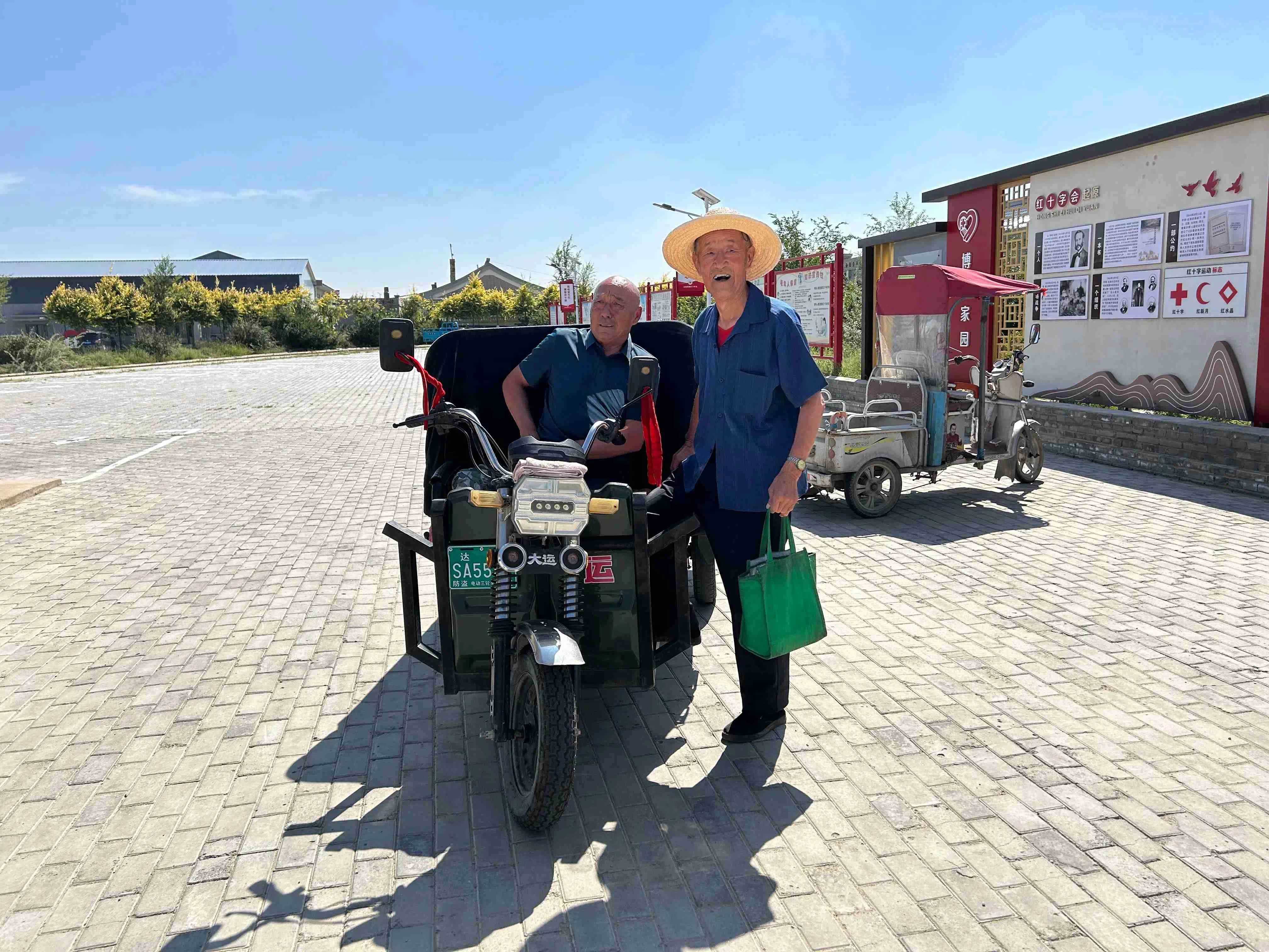 食堂工作人員祁二飛（左）出發給老人送餐。人民網記者 鄭莉茵攝