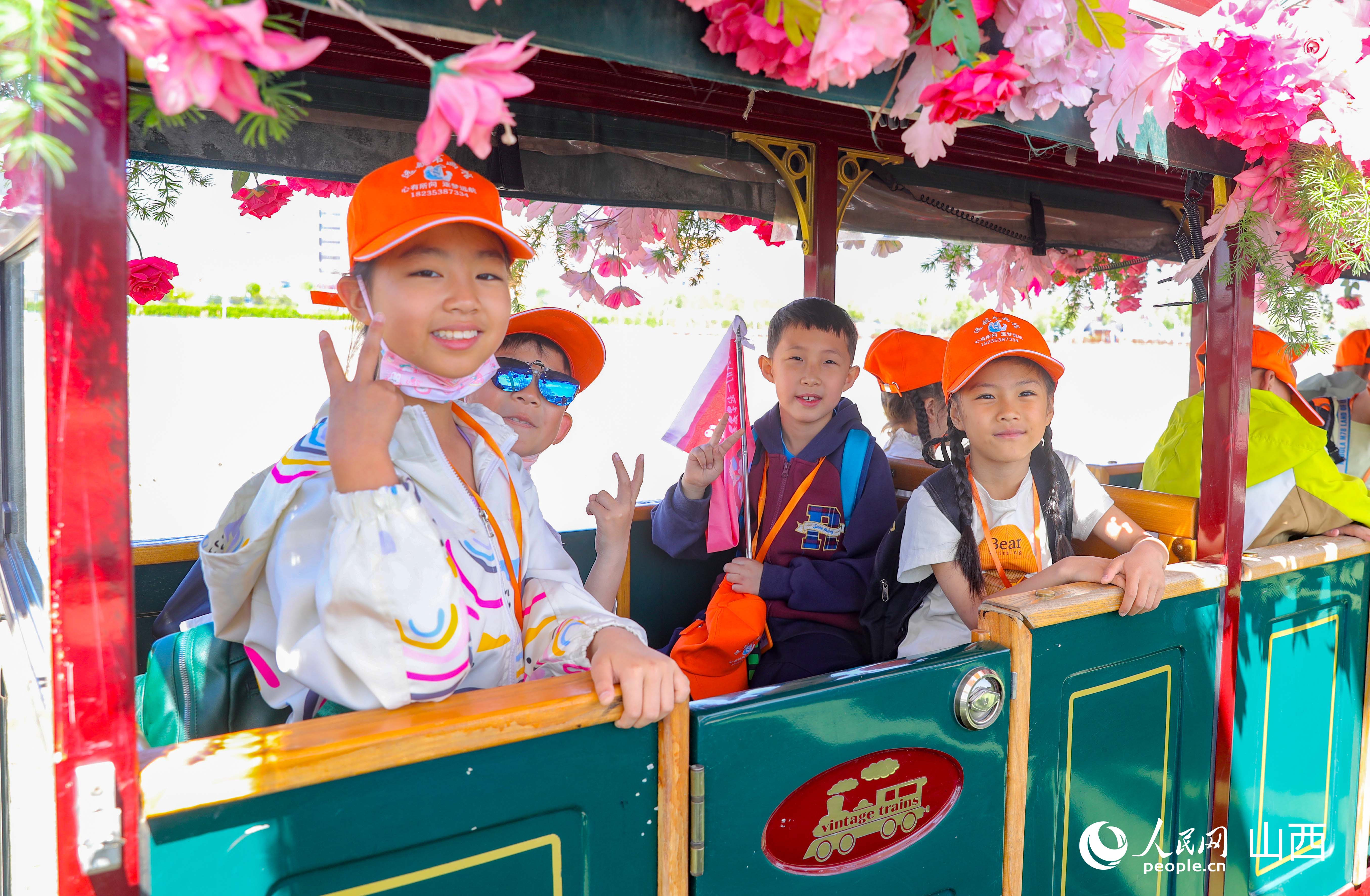 研學少年坐上小火車拍照打卡。