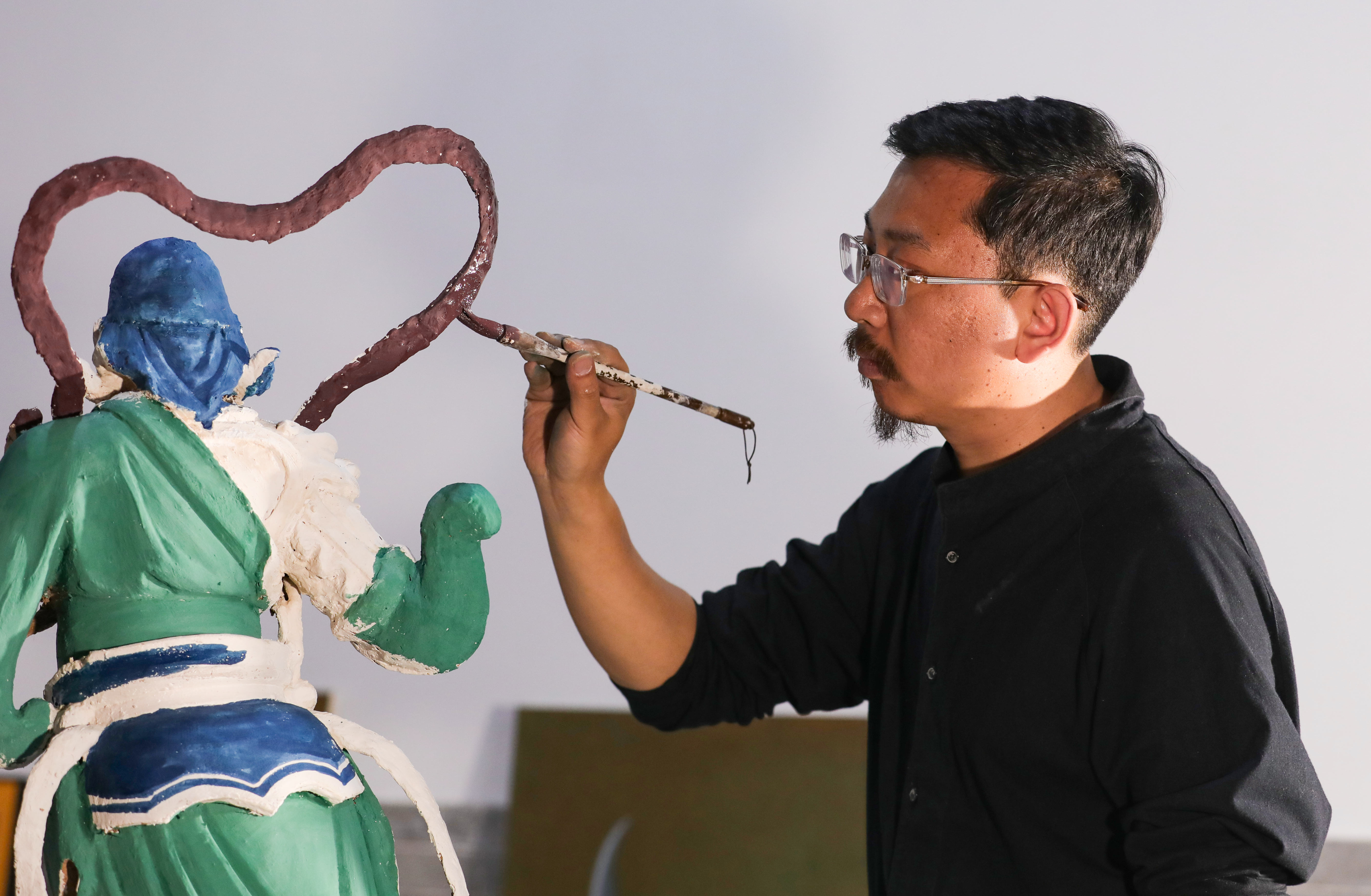 劉子群為彩塑上色。王帆 攝