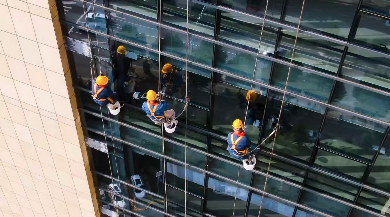 祥達家政公司為客戶清潔高層辦公樓玻璃。