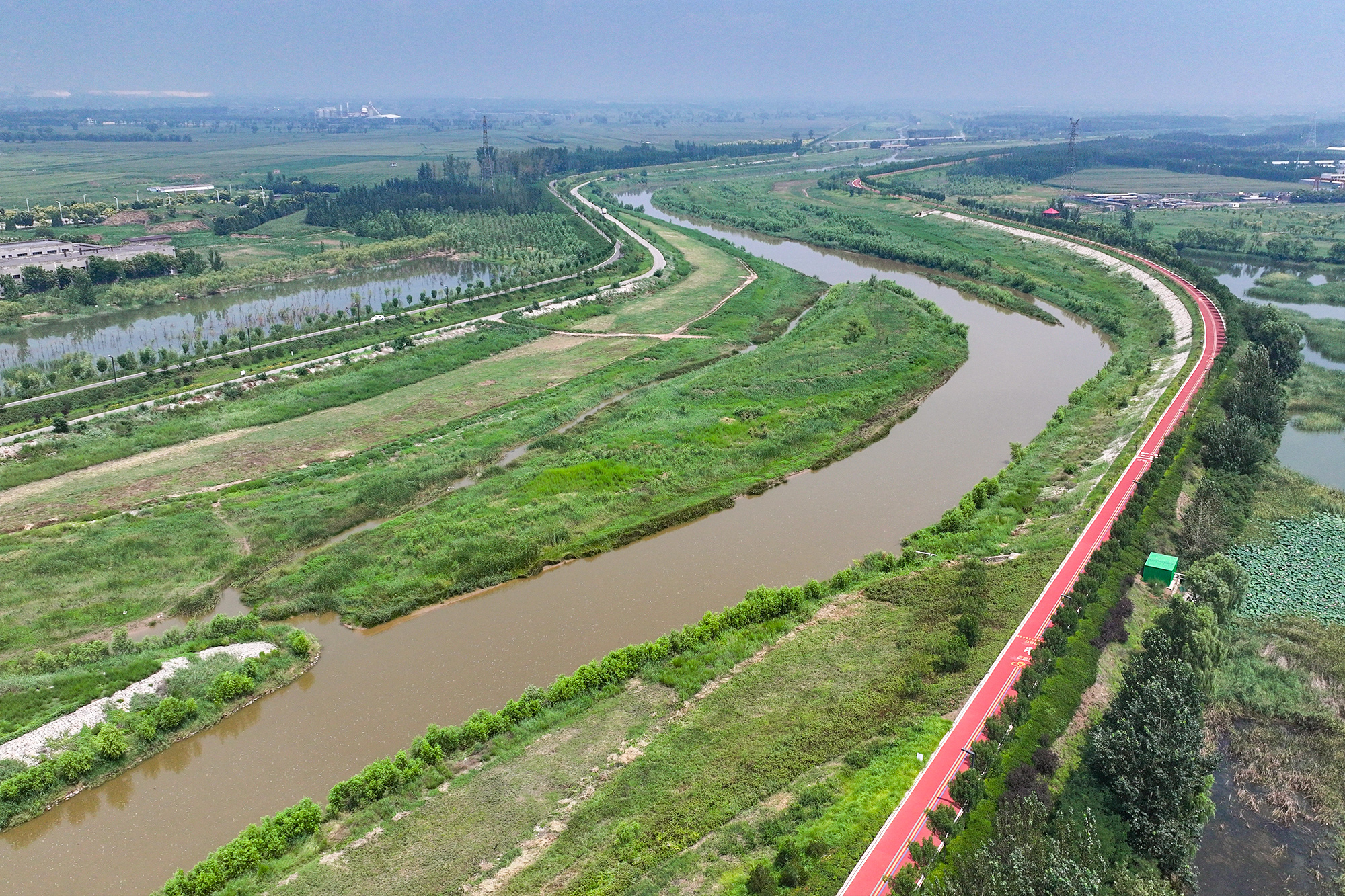 山西省晉中市介休汾河國家濕地公園內，沿河蜿蜒的塑膠跑道，成為人們休閑健身的好去處。王璟攝