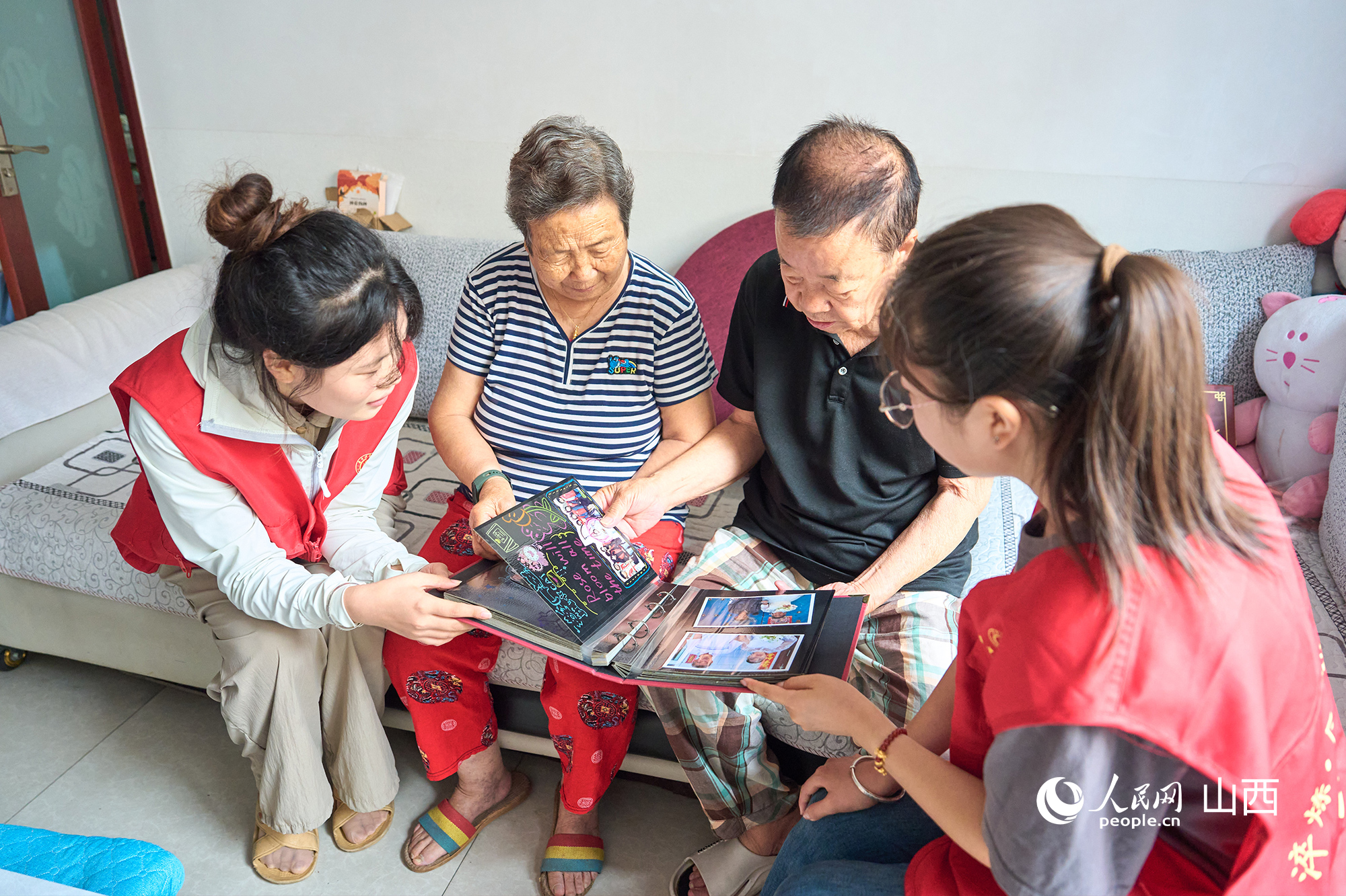 志愿者和老人一同看“時光紀”相冊。張超寧攝